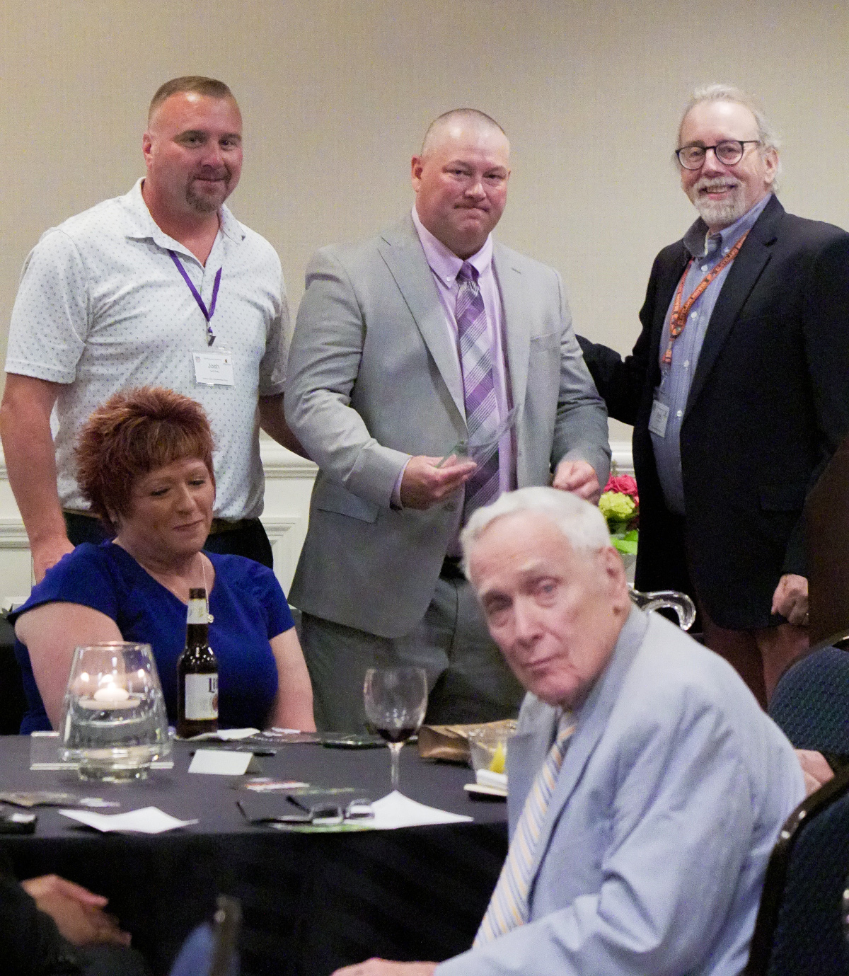 PJ Doyen is presented with the 2025 Tommy Bell Referee of the Year award by Blanton Collier Group Board Members, Rob Schmid and Josh Roby.